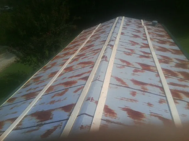 Rusted metal roof panels with new wood purlins before replacement — Storm Damage Roof Repair in Galveston by Roofing Brothers