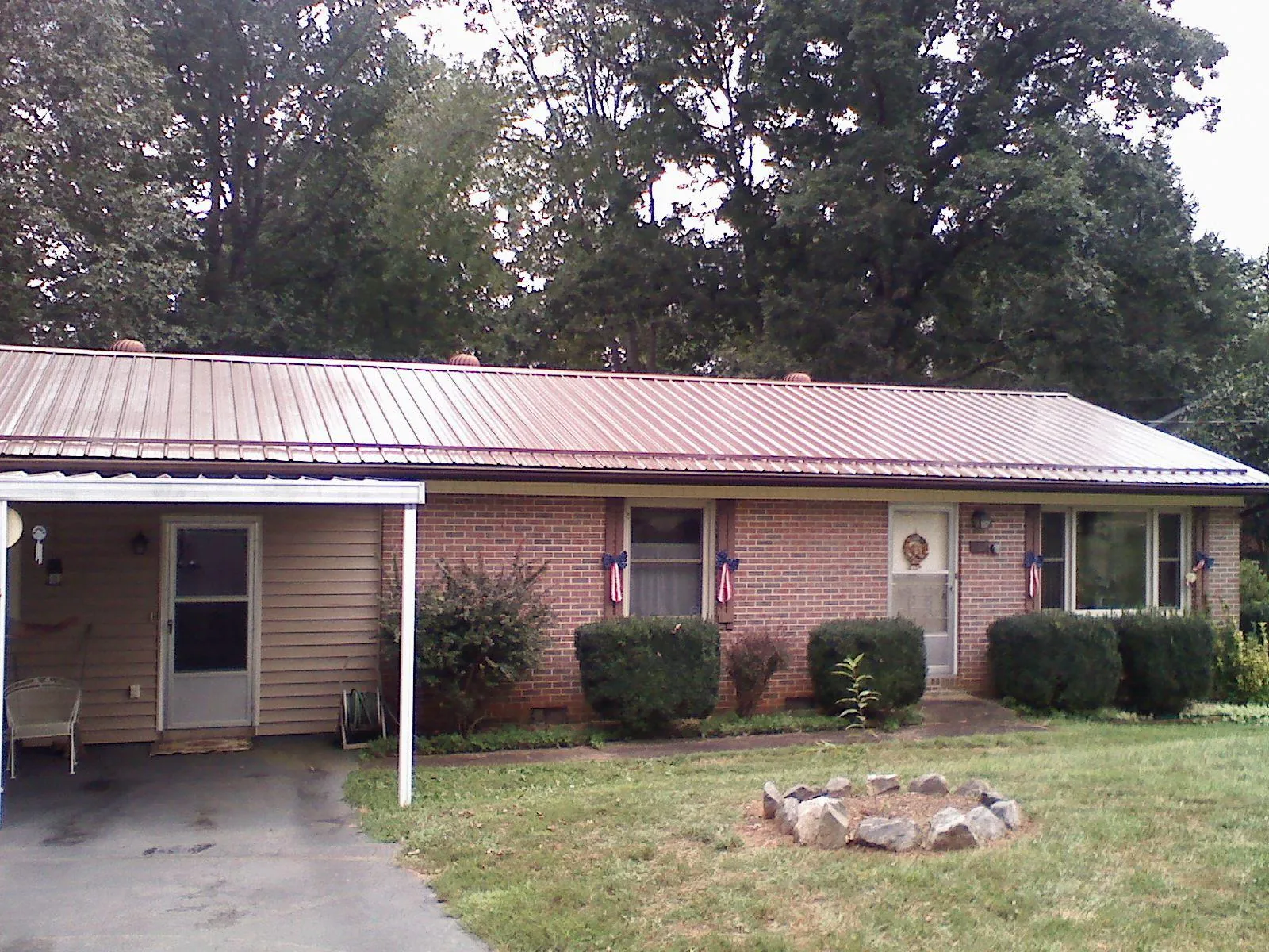 Bronze metal roof and carport on a brick ranch home — Roof Repair work by our crew in Galveston